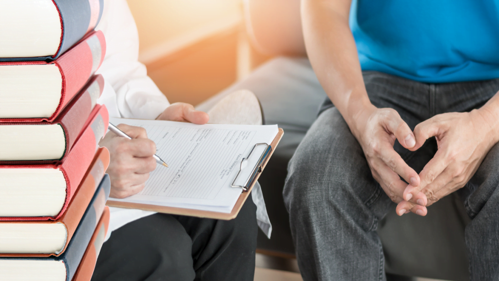 Bild p åböcker och en patient och läkare s händer som sitter i samtal