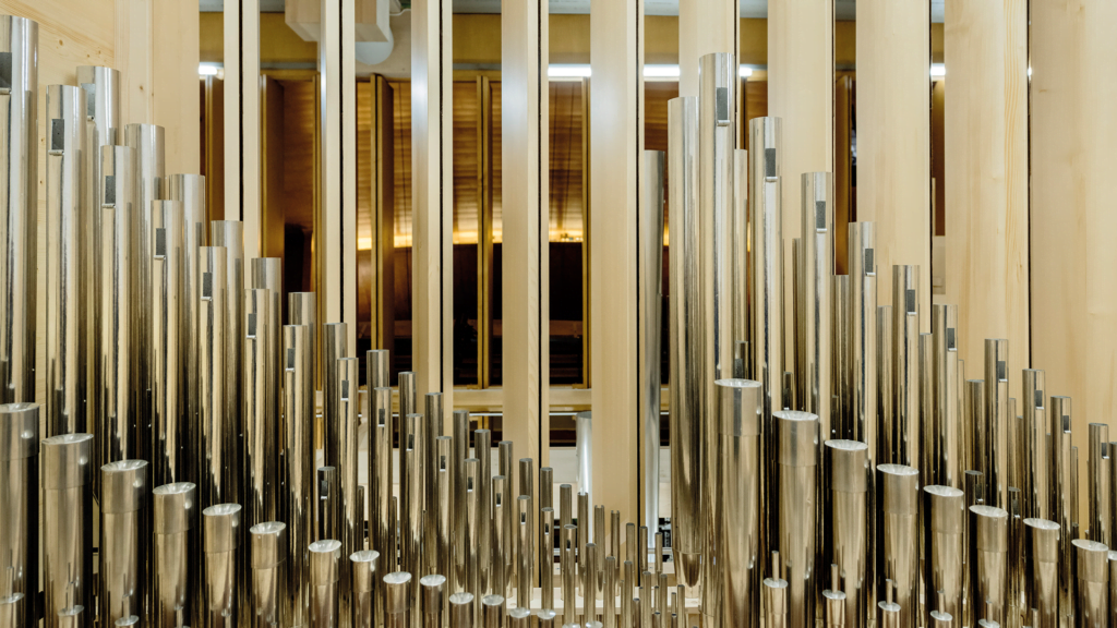 Orgelnn blanka pipor i olika höjder i närbild.