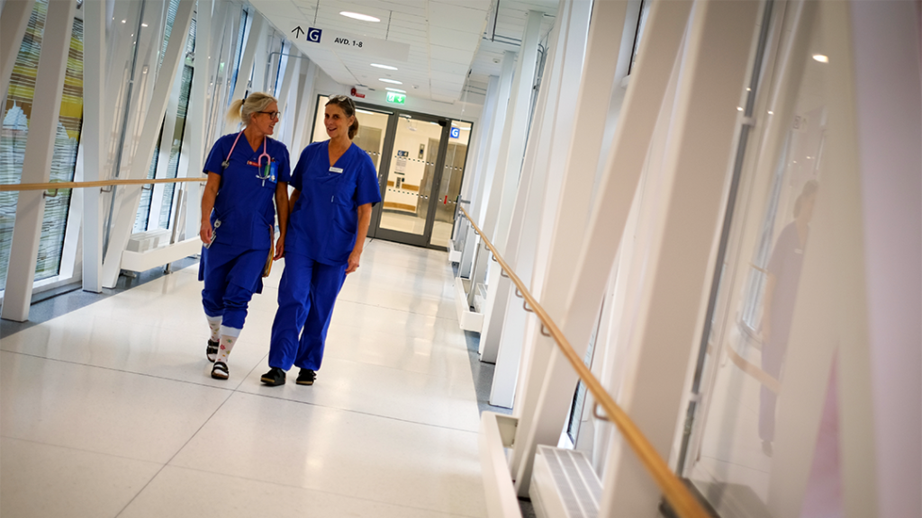 Två sjuksköterskor går i en korridor.