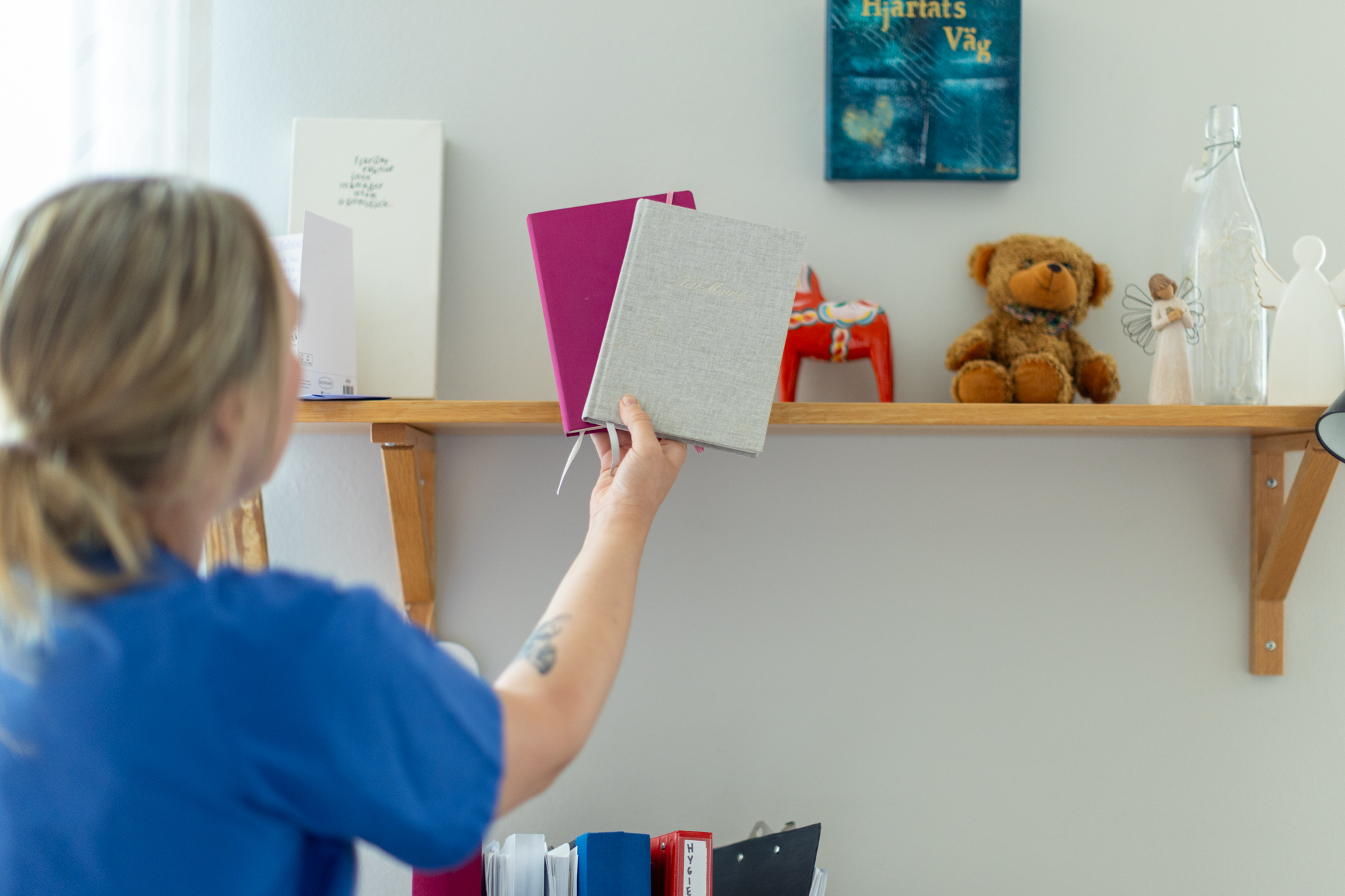 kvinna tar ner bok från en hylla