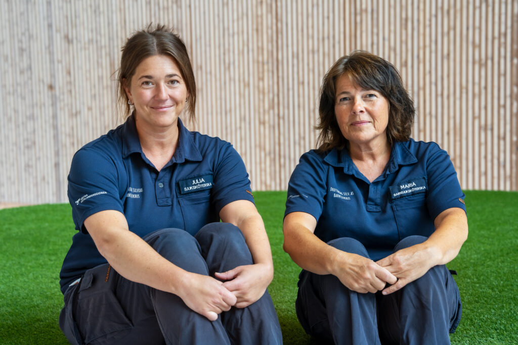 Två kvinnor som sitter på en grön matta.