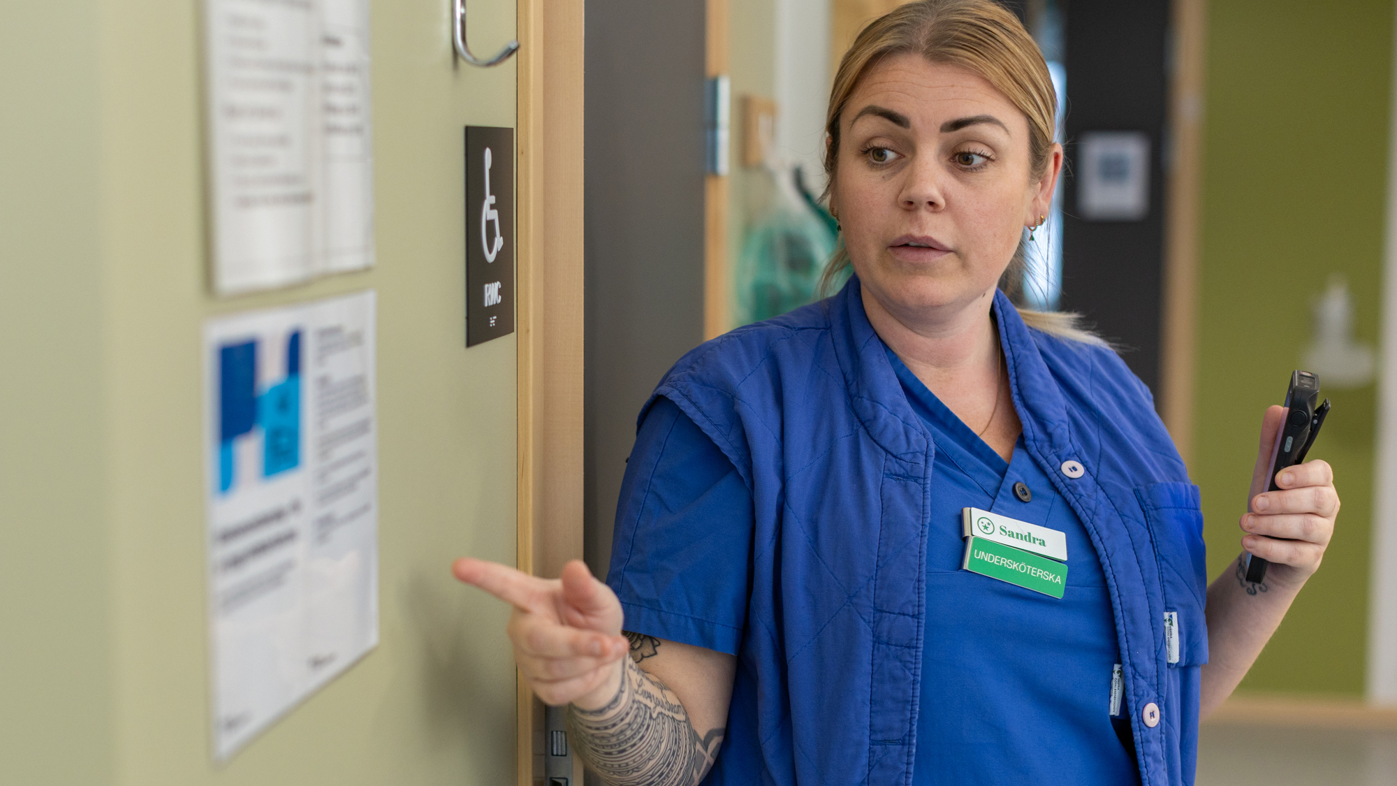 Kvinna står upp och pekar på en skylt.