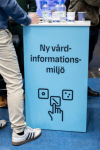 En man står vid ett podium med texten Ny vårdinformationsmiljö.