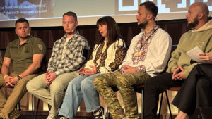 Personer i en panel på en scen.