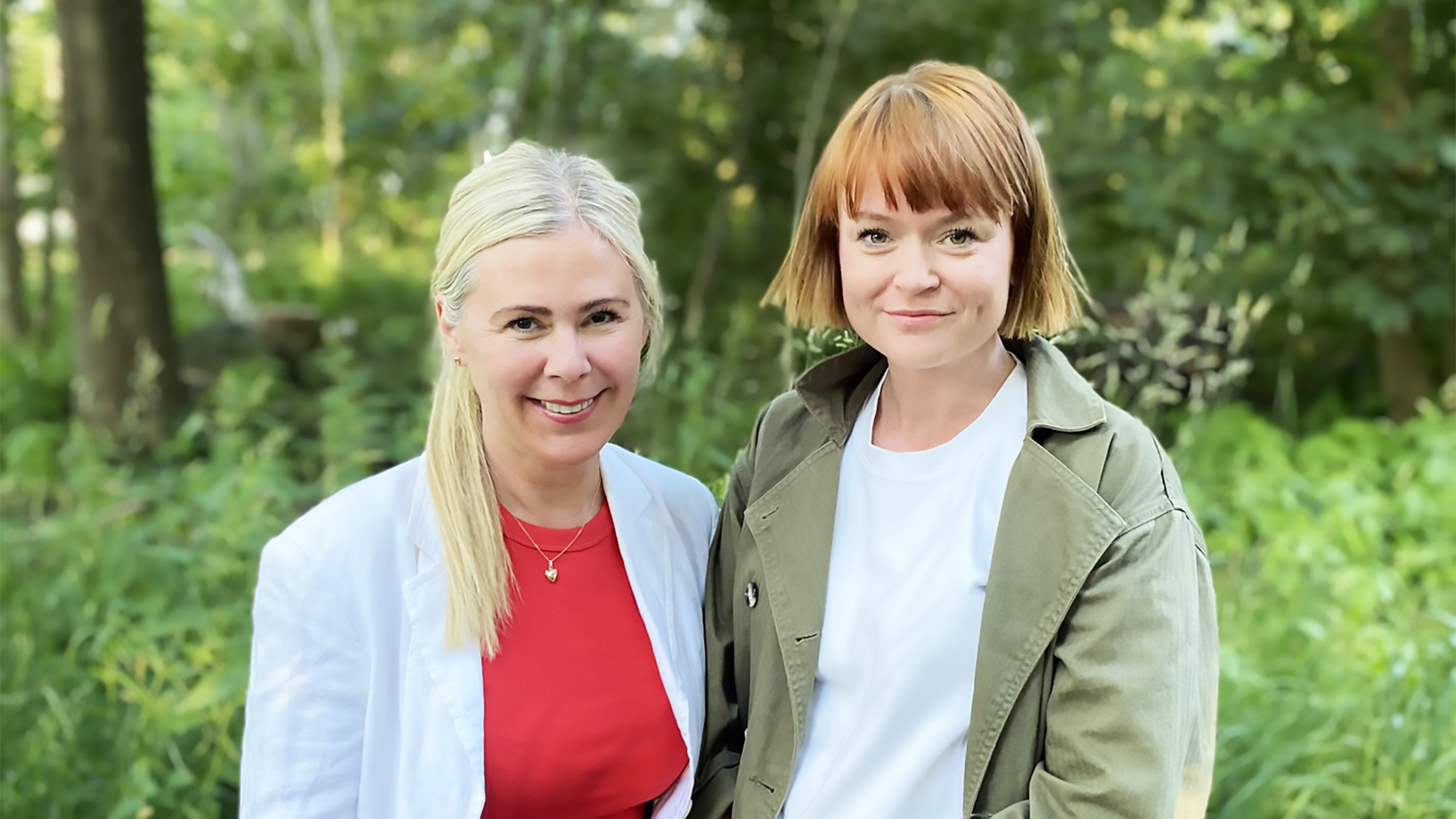 Två kvinnor står intill varandra utomhus,
