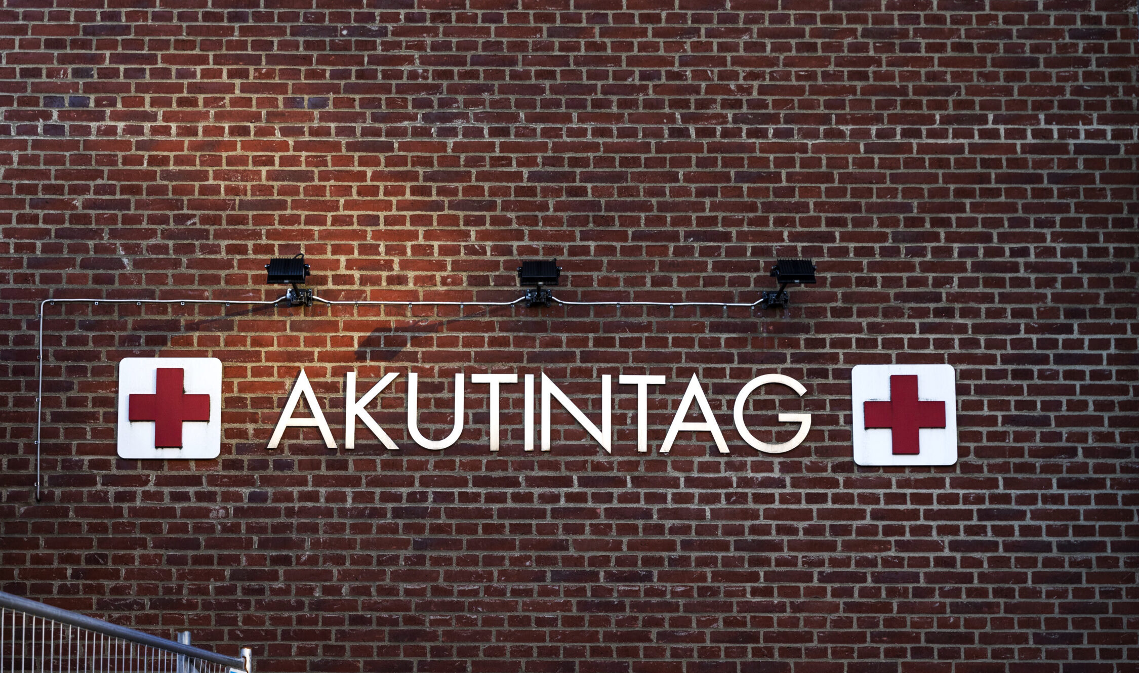 Ordet akutintag textad på en tegelvägg.