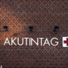Ordet akutintag textad på en tegelvägg.